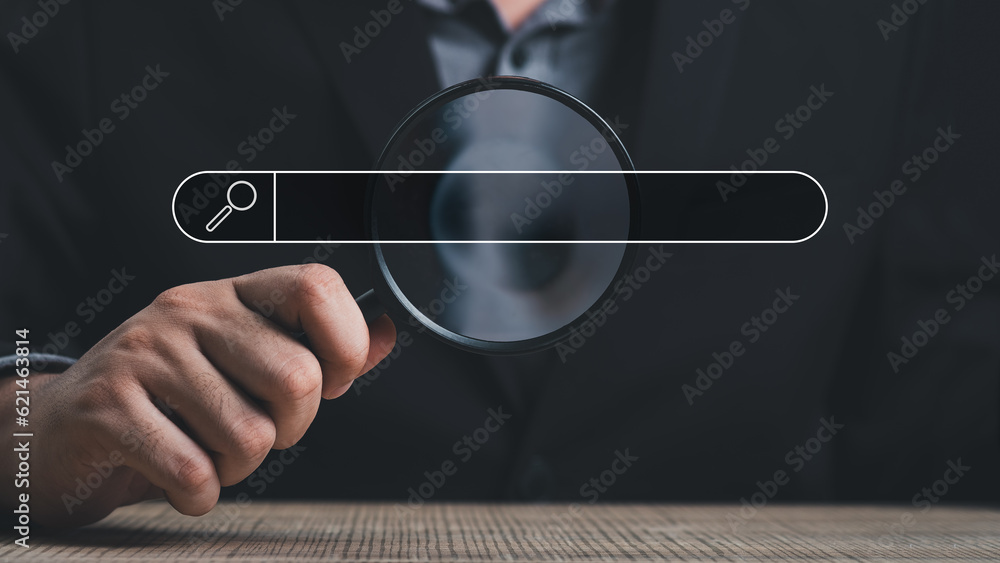 Wall mural hand holding magnifying glass. searching for information. using search console with your website. da