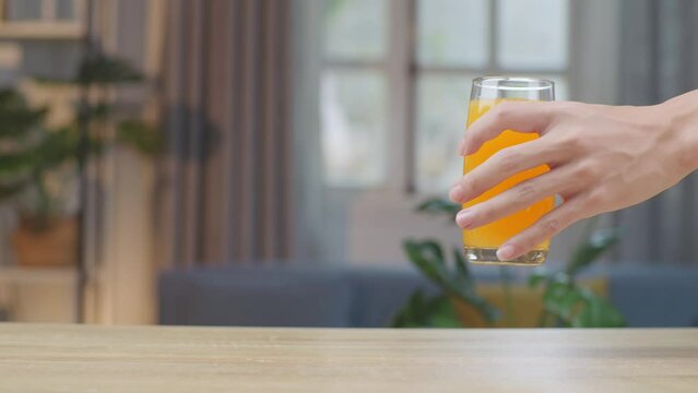 Man Hand Place Glass Of Orange Juice On Table
