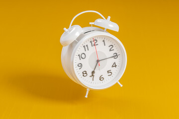 White vintage alarm clock on bright orange color background. Time management, deadline concept. 3d rendering