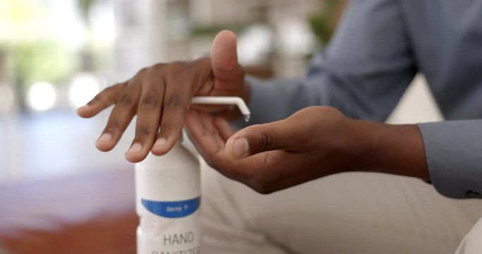 Man, hands and sanitizer for disinfection, hygiene and washing in health, safety and protection at home. Closeup of male person by liquid bottle and rubbing hand together for bacteria or germ removal