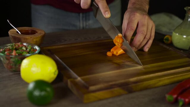 Cutting Orange Jalapeno on the wooden board