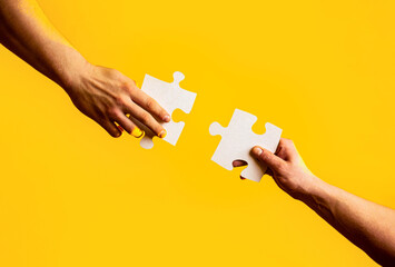 Business solutions, success and strategy concept. Two hands trying to connect couple puzzle with...