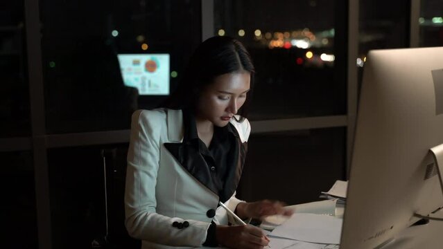 Young businesswoman in workplace discussing and consult planning with brainstorming meeting in office to night. Business woman planning and trading with negotiate partnership.