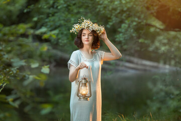 girl is standing in the forest  an old kerosene lamp in her hands