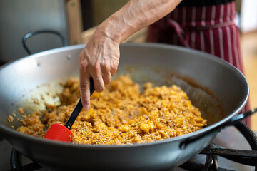 Chef cooking paella for a group of diners