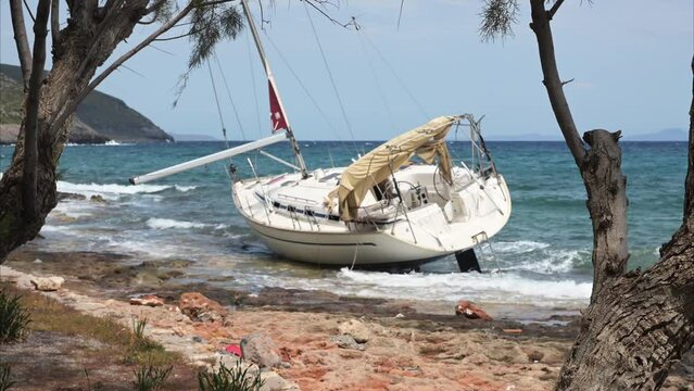Wreck of a recreational sailing yacht beached on the shore