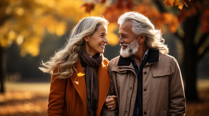 Fototapeta premium Lovely happy gray-haired Caucasian-aged couple enjoying health-promoting, breathing fresh air in autumn season nature, backside senior couple walking together in the park, morning