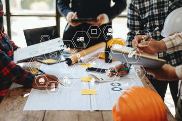 Engineer desk with object paper and tablet with blurry engineer teamwork hardworking to consults about their building project.