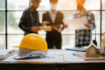 Engineer teams meeting working together wear worker helmets hardhat on construction site in modern city.Asian industry professional team in office