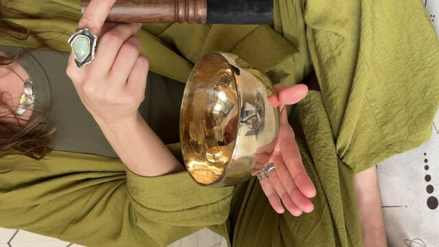 Tibetan singing bowl music meditation by hand rotation with healing vibration. Woman using use singing bowls during yoga session. Addition of energy, strength, and beauty to body, mind, and soul.