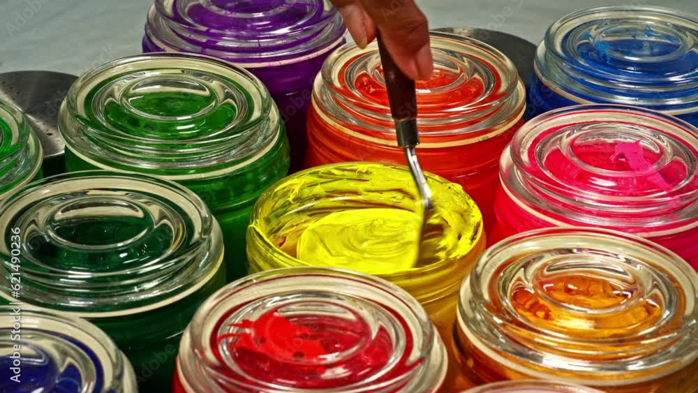 Aufkleber use a trowel to stir the reflective yellow into a clear glass bottle..the subtle hues swirled togeth