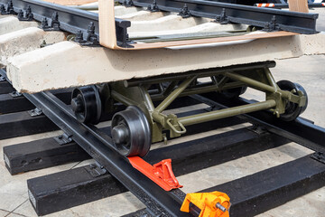 Railroad laying. Trolley for installation rails. Railroad repair process. Rails with concrete sleepers on bogie infrastructure for train traffic. Railway construction. Railroad replacement equipment