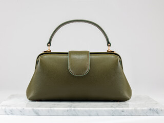 Luxury women 's bag. Luxury dark green leather handbag on white background, on marble floor. A elegant bag. Fashionable trendy 