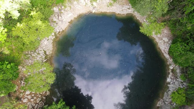 Drone rise up above emerald pool at lom poo kiew in Lampang Province, Thailand.