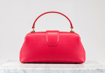 Luxury women 's bag. Luxury red leather handbag on white background, on marble floor. A elegant...