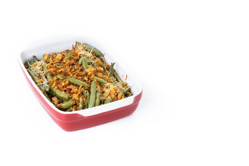 A traditional green bean casserole topped with French Fried Onions and cream of mushroom isolated on white background. Copy space