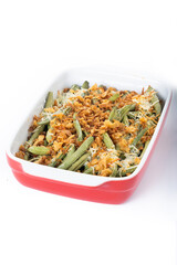 A traditional green bean casserole topped with French Fried Onions and cream of mushroom isolated on white background. 