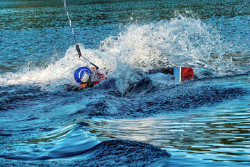 A man wakeboarding on a lake on summer day in a life  jacket. Soft focus. Action blur.