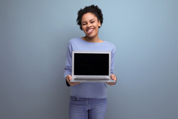 positive young afro brunette woman showing laptop screen with advertising space