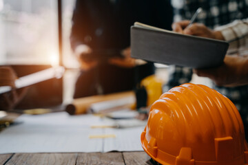 Engineer teams meeting working together wear worker helmets hardhat on construction site in modern city.Asian industry professional team.