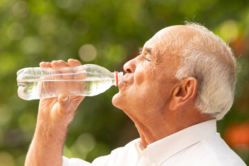 senior man in summer drinking water