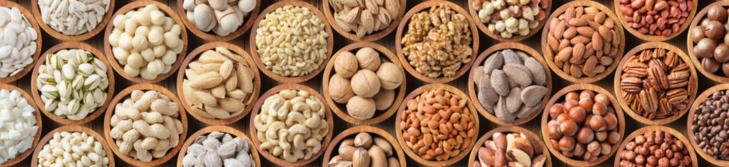 assorted nuts and seeds in wooden bowls, healthy food background.
