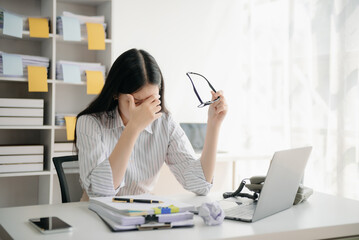 Woman who is tired and overthinking from working with tablet and laptop at modern office.