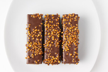 waffles in chocolate and nuts on a white plate, top view