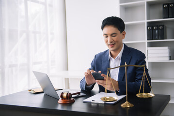 Attractive young lawyer in office Business man and lawyers discussing contract papers laptop and tablet with brass scale on  desk in office.