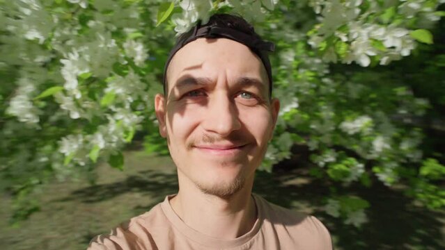 Positive man millennial good mood take video selfie outdoors spring.