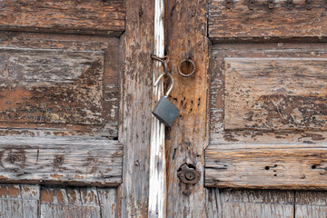 rusty rings and padlock on old rotten door