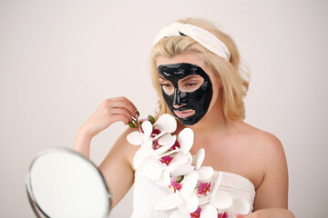 Skin care. Portrait of a young girl with a black mask on her face.