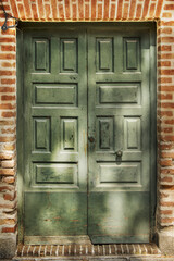 A green painted paneled wooden double door