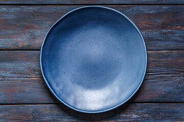 Empty blue plate on old rustic wooden table - 621520407