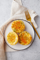 Savory muffins with egg, feta cheese, cheddar and spinach on light background