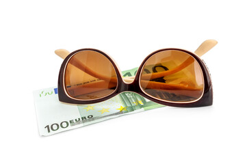 Sunglasses with one hundred euro bill on a white.