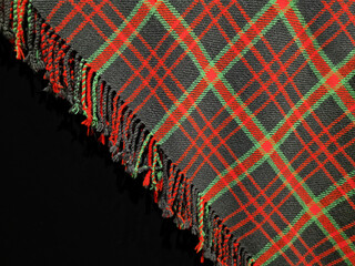 Latvian traditional hand-woven red and green checkered wool blanket corner with fringes