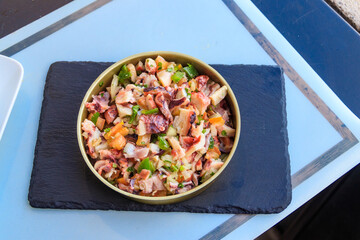 Fresh healthy octopus salad on a table. Top view