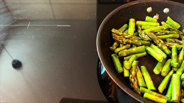 Fried potatoes in a pan. Asparagus. Frying asparagus in a pan.