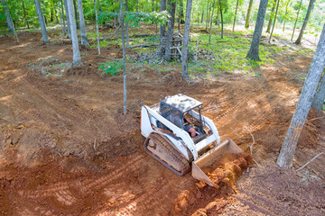 Fototapeta na wymiar Use of tractor in construction enablese movement heavy earth materials, making it easier to level ground create to solid foundation.