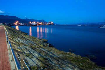 Obraz premium Coast of the port of Ushuaia at sunset with large ships with their lights on