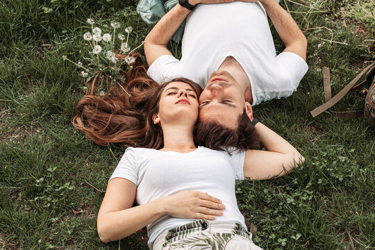 Top view of a young romantic couple lying in the grass