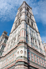 Looking up at the fabulous Campanile di Giotto bell tower made of white, green and red marble, of the iconic Italian Cathedral, Santa Maria del Fiore in Piazza del Duomo, Florence, Italy