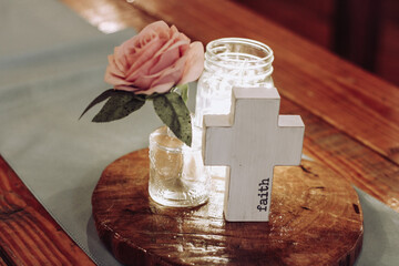A pink flower with a cowbell and Mason jar with fairly lights as a table decoration for a wedding or special romantic event stock photo for editorial or commercial use. 