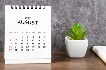 The August 2023 Monthly desk calendar for 2023 with diary on wooden table.