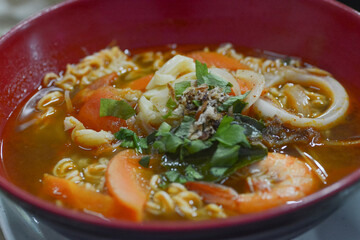 A close-up view of instant curry noodles with vegetables and prawns.