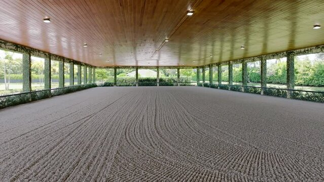Spacious empty squad for horse riding with clear adjusted sand instead of floor. Modern ranch in countryside suitable for dressage horses