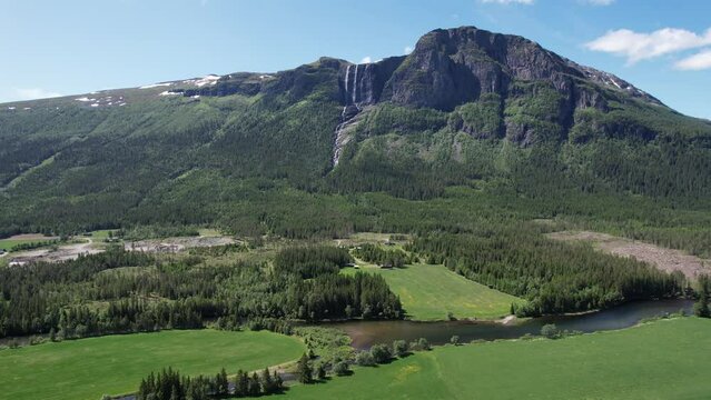 Aerial video of rivers and waterfalls pouring into a river in a green area in Norway