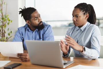 Obraz premium African American business couple working on a computer in the office. Focus is on man