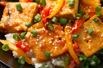 Homemade Stir Fry Tofu with Vegetables and Rice in black bowl.